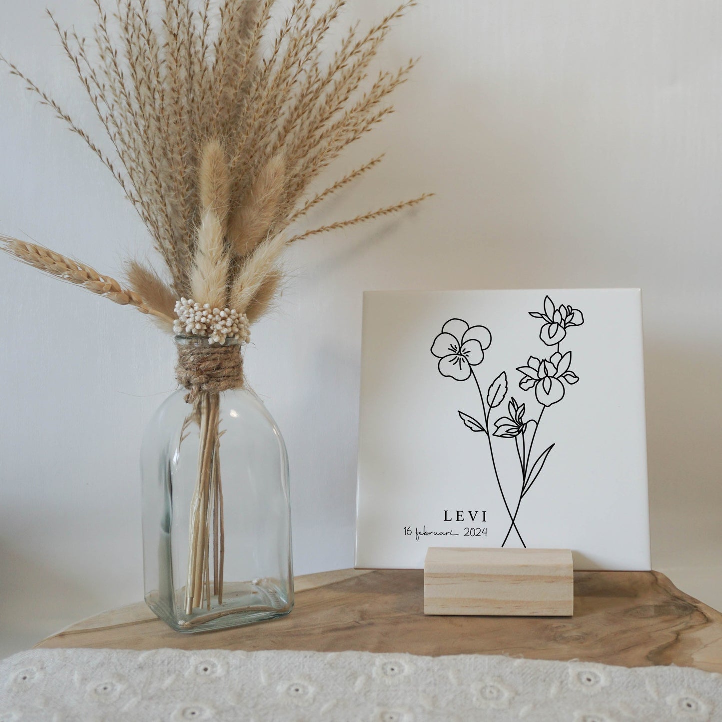 Gepersonaliseerde geboortebloemtegel van februari op een elegante houten standaard.
