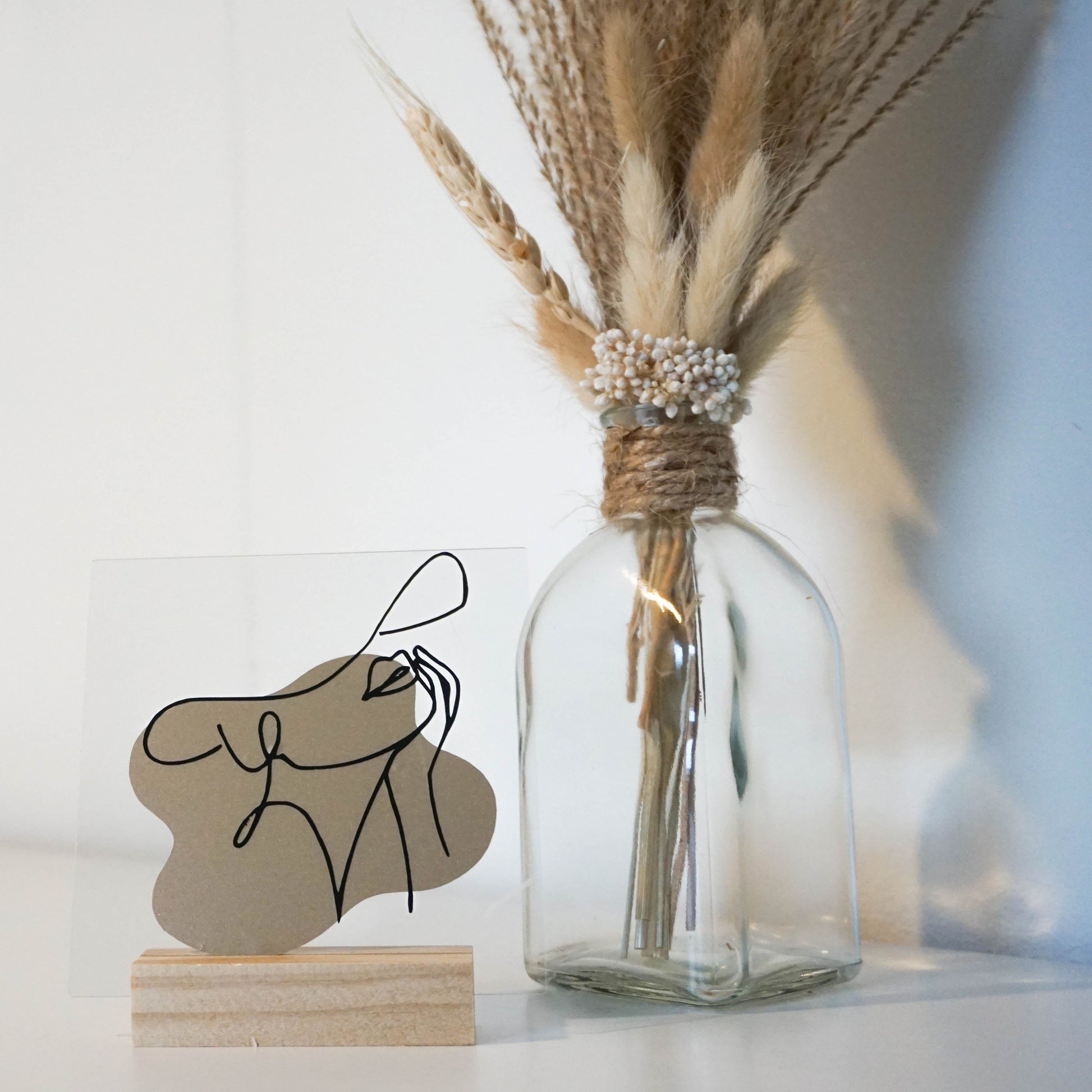 De acrylplaat staat op een eenvoudige houten standaard.
