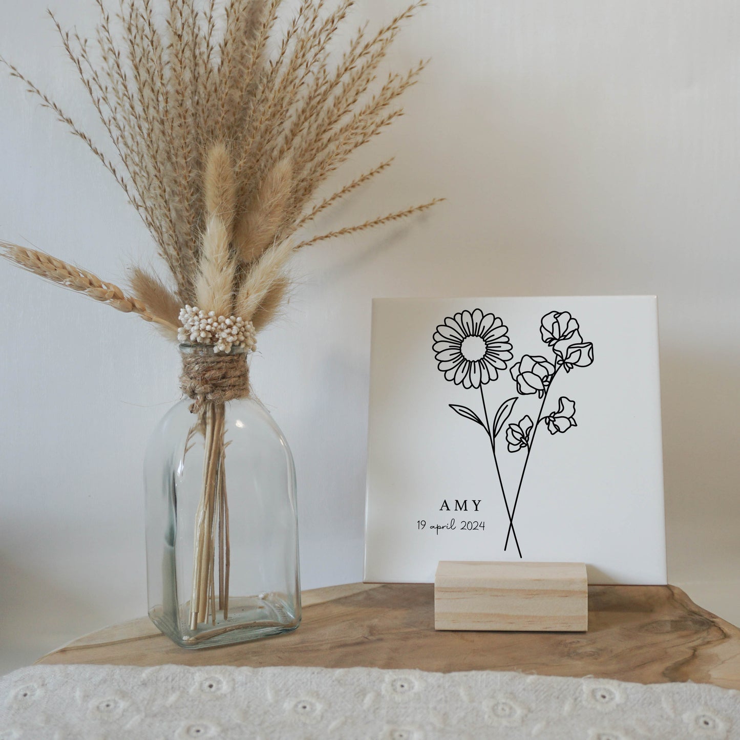 Gepersonaliseerde geboortebloemtegel van april op een elegante houten standaard.