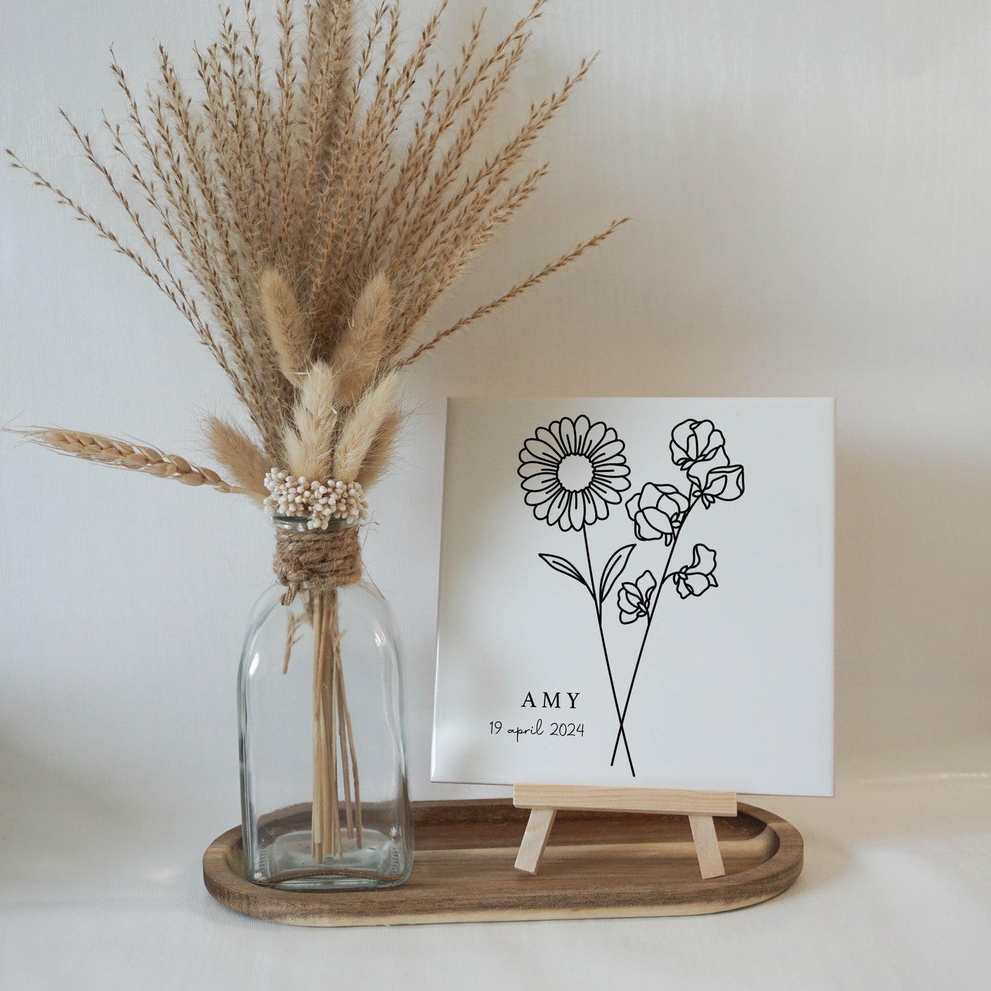 Gepersonaliseerde geboortebloemtegel van april op een elegante houten standaard.