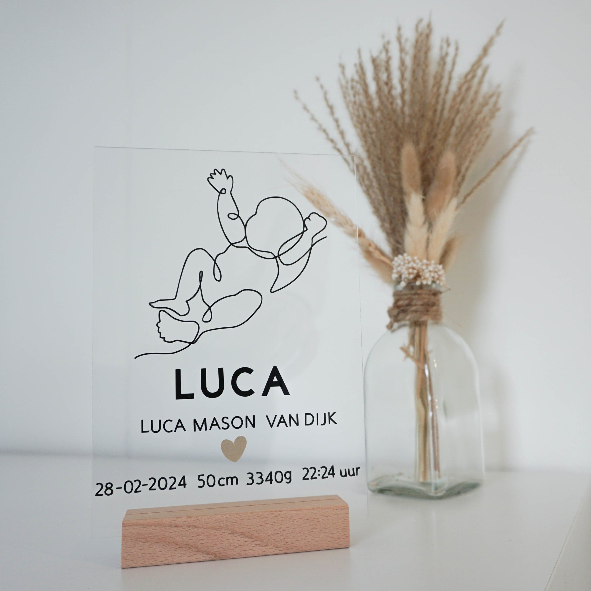 Een transparant acrylglas frame met een gepersonaliseerde line art illustratie van een baby.